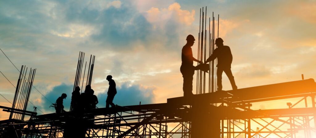 Construction workers shaking hands on steel structure