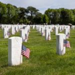 American flags next to tombstones in cemetery for Memorial Day 2026