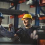 Two construction workers grasping hands - showing grace